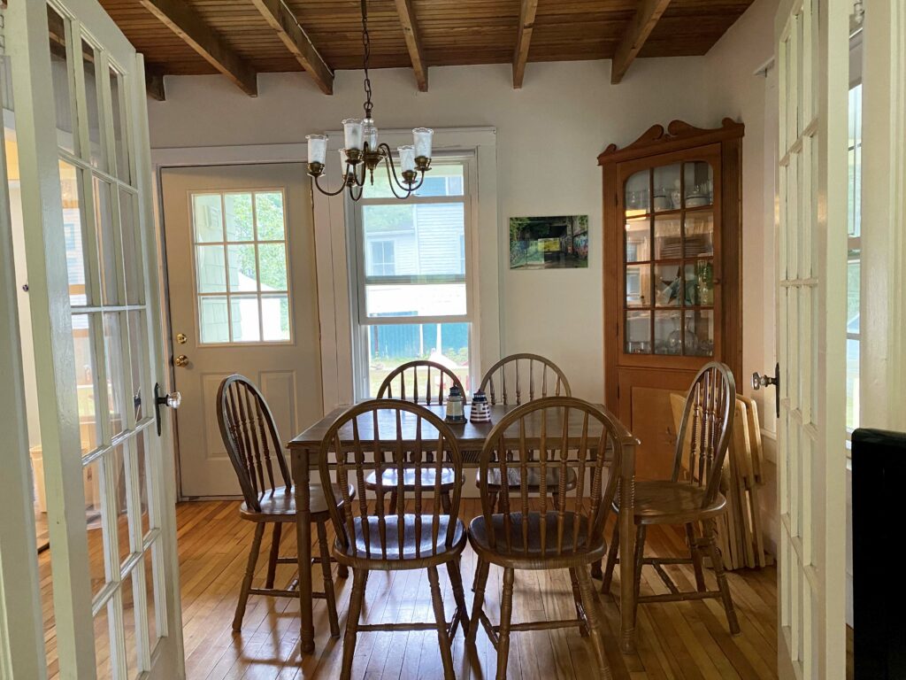 Dining room with french doors, table and six chairs.