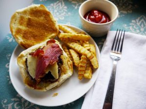 A bacon cheeseburger with fries.
