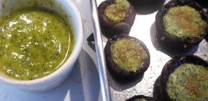 Green pesto in ramekin with stuffed mushrooms